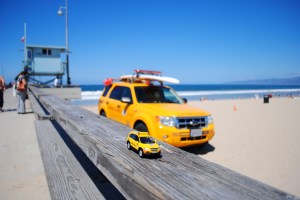 Little Captiva posing in front of lifeguard car & tower, Venice Beach, California