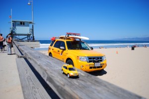 Little Captiva posing in front of lifeguard car & tower, Venice Beach, California